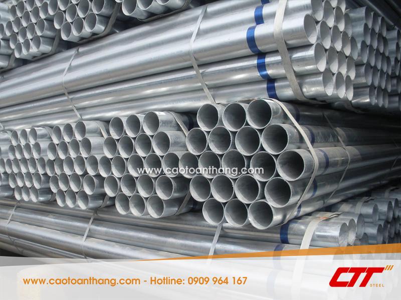 Hình ảnh minh họa cách bảo quản ống thép tráng kẽm DN100 trong kho hoặc công trường, được kê cao và che chắn cẩn thận