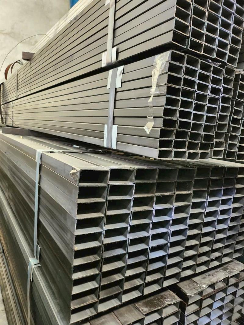 Người công nhân hoặc kỹ sư đang xem và so sánh báo giá sắt hộp mạ kẽm trên giấy hoặc máy tính bảng để lựa chọn vật liệu phù hợp